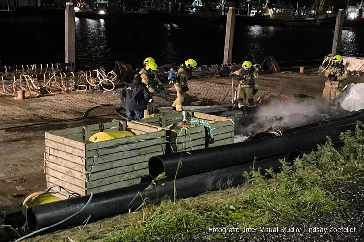 Goederen van schip vatten vlam aan Oostkade in Den Oever